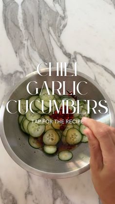 someone is cooking cucumbers in a pan on the counter top with text overlay that reads chili garlic cucumbers tap for the recipe