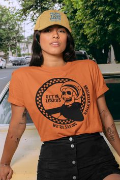 🖤 Product Details:- 100% Soft Ring-Spun Cotton- Light fabric that runs true to size- Unisex- Made in the USA 🇺🇸 🖤 Description:Step into nostalgia and embrace the '90s spooky vibes with our "Get in Losers We're Saving Halloweentown" tee – the ultimate retro tribute to the iconic Skeleton Taxi! Channel your inner Halloween enthusiast as you sport this vintage-inspired gem featuring eerie graphics and eerie appeal. Whether you're cruising through the season or just want to make a spooky stateme 90s Style Tops For Fan Merchandise In Fall, 90s Style Halloween Streetwear Top, Retro Fan Merchandise Tops For Fall, Retro Fall Tops For Fan Merchandise, 90s Halloween T-shirt With Screen Print, Retro Halloween T-shirt For Streetwear, Vintage Cotton Tops With Skull Print, 90s Crew Neck Halloween Tops, Vintage Crew Neck Halloween Tops