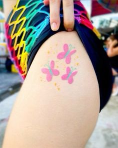 a person with a tattoo on their leg and butterfly designs on the back of her thigh