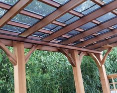 a wooden pergol with glass panels on the roof