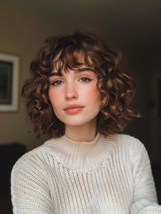 The curly bob with bangs is a timeless style that combines the playful nature of curls with the chic look of bangs. This hairstyle is perfect for those who want to frame their face and highlight their eyes. It’s particularly flattering for women with oval or heart-shaped faces, and it works well with any hair color, making it a versatile choice. Whether you’re heading to a casual brunch or a formal event, this style can be dressed up or down to suit the occasion. Bangs Haircut Curly Hair, Short Permed Hairstyles With Bangs, Short Natural Curly Hair With Bangs, Short Curly Haircut With Bangs, Curly Italian Bob, Curly Bob Round Face, Short Hair With Bangs Curly, Curly Bangs Short Hair, Curly Hair Bob With Bangs