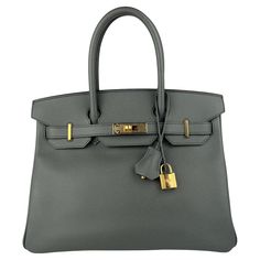 Ultra Rare Absolutely Stunning Hermes Birkin 30 Vert Amande Epsom Leather, Complimented by Gold Hardware. Pristine Condition with plastic on all Hardware. Excellent corners and structure. Z Stamp 2021. Please keep in mind that this is a pre owned item, the bag has been carried before, unless otherwise stated. The handbag may be in pristine condition but is not flawless. Please carefully review the detailed photos on the listing. Shop with Confidence from Lux Addicts. Authenticity Guaranteed! Birkin 30, Hermes Birkin 30, Handle Bag, Hermes Birkin, Fashion Handbags, Gold Hardware, Green And Grey, Top Handle Bag, Purses And Bags