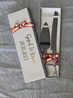 a couple of forks and spoons in a box with a ribbon around it's edge