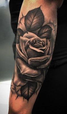 a black and white rose tattoo on the arm