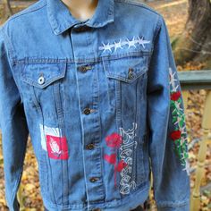 a blue jean jacket with red, white and green designs on it