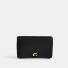 a black wallet with a gold logo on the front and side, sitting against a white background