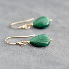 These Malachite drop earrings feature genuine green Malachite teardrops. Each earring showcases a unique Malachite stone, renowned for its stunning green hues and distinctive patterns. These earrings are perfect for those who appreciate natural gemstones and want to incorporate them into their everyday wardrobe. 💎 Also available in sterling silver. 📏Measurements📏 The stones measure 14x10mm. The earrings measure approximately 30 mm in length and 10 mm in width.                💎Matching Neckla Green Gemstone Teardrop Earrings, Green Teardrop Gemstone Earrings, Luxury Green Teardrop Gemstone Earrings, Malachite Earrings, Gemstone Drop Earrings, Malachite Jewelry, Basic Jewelry, Green Malachite, Malachite Stone