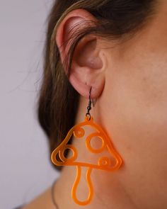 Get psychedelic with these cool Mushroom Cutout Earrings!Mushroom Cutout Earrings- Pairs great with the One Stop Rave Psilo Hand Fan.- Lightweight earrings for music festivals, raves & more!- Features a funky mushroom shape.- Exclusive design by OSR.- Glows under blacklight.- Designed, handmade & laser cut in Las Vegas, NV.- Stainless steel jump ring & ear wire.- Rubber earring back included.- 2.5” X 1.5“ acrylic charm. Mushroom Cutout, Earrings Mushroom, Taste The Rainbow, Acrylic Charms, Lightweight Earrings, Music Festivals, Earring Sale, Light Weight Earrings, Party Shirts