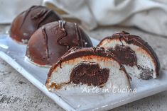 three chocolate covered donuts on a white plate