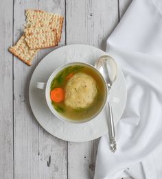 a white plate topped with soup and crackers