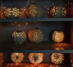 some pumpkins are sitting on shelves with lights