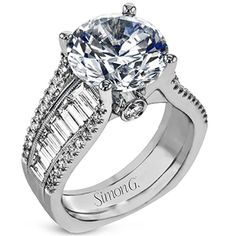 a white gold engagement ring with baguetts and side stones on the band, set in