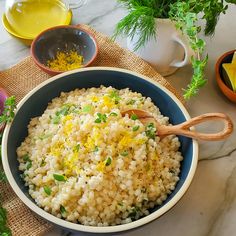 a blue bowl filled with rice and topped with lemon zest next to other dishes