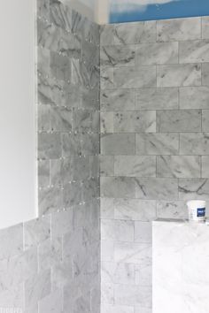 a bathroom with white and gray marble tile