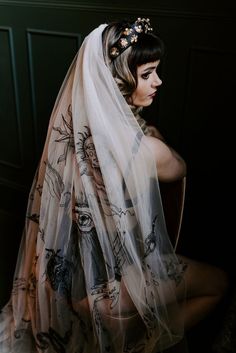 a woman wearing a veil with flowers on it