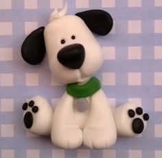 a close up of a toy dog on a checkered tablecloth background with black and white paw prints