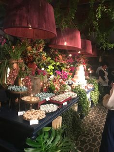 a buffet table filled with lots of desserts and flowers on it's sides