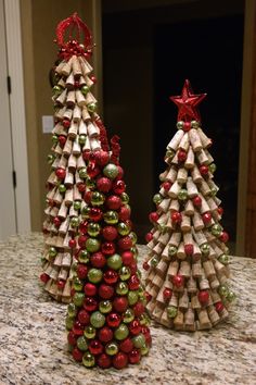 two christmas trees made out of wine corks on a kitchen counter with red and green ornaments