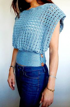 a woman wearing a crochet top and jeans