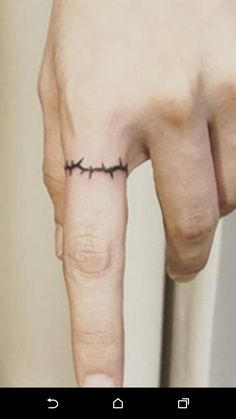 a person's finger with a small tattoo on it