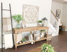 a wooden table sitting in the middle of a living room next to a stair case