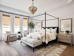 a bedroom with four poster bed and white furniture