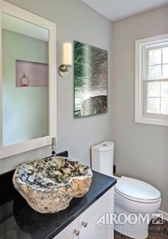 a bathroom with a sink, toilet and mirror in it's centerpieces