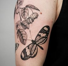 a black and white butterfly tattoo on the arm