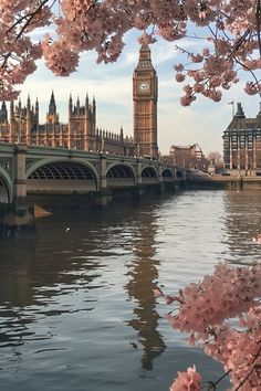 the big ben clock tower towering over the city of london from across the river thames