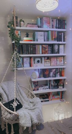 a white hammock chair sitting in front of a book shelf filled with books