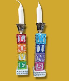 two candles are decorated with letters that spell out love