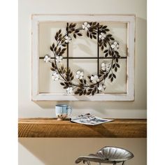 a coffee table with a wreath on it and a cup in front of the window