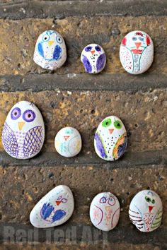 four painted owls sitting on top of each other next to an egg with three smaller ones