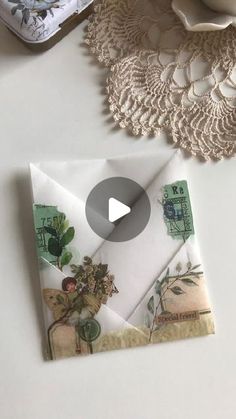 an open envelope sitting on top of a table next to doily and other items