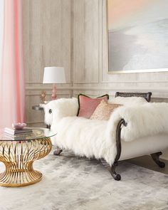 a white couch sitting next to a glass table with a lamp on top of it