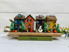 there is a miniature house on top of a book with trees in front of it