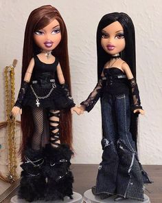 two dolls standing next to each other holding hands