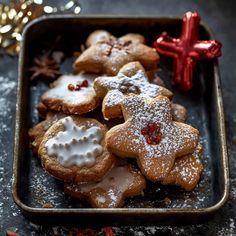 christmas cookies with icing and decorations on a tray