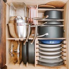 a cabinet filled with lots of pots and pans