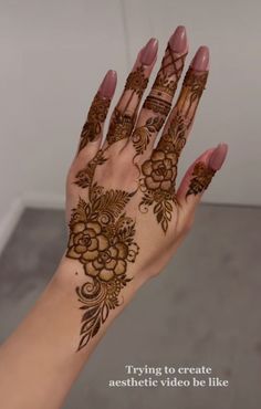 a woman's hand with henna tattoos and flowers on her hands, showing the intricate