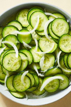 sliced cucumbers and onions in a white bowl