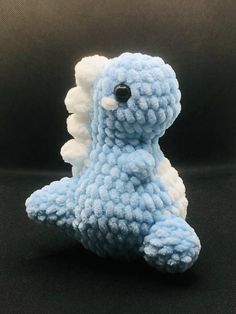 a small blue and white stuffed animal on a black background