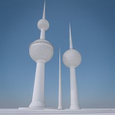 two tall white towers are in front of a blue sky and some snow on the ground