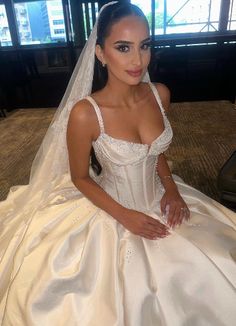 a woman in a wedding dress sitting on the floor