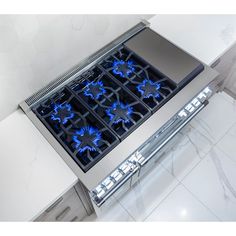 a stove top with blue flames on it's burners in the middle of a kitchen