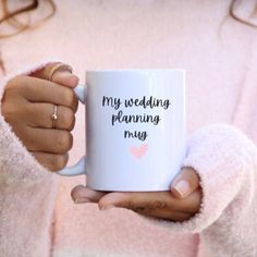 a woman holding a white coffee mug with the words, my wedding planning mrg on it