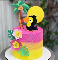 a colorful cake with a toucan and palm tree on top