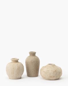 three white vases sitting next to each other