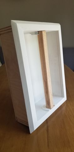 a wooden object in a white box on a table