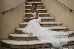 a woman in a wedding dress sitting on some steps